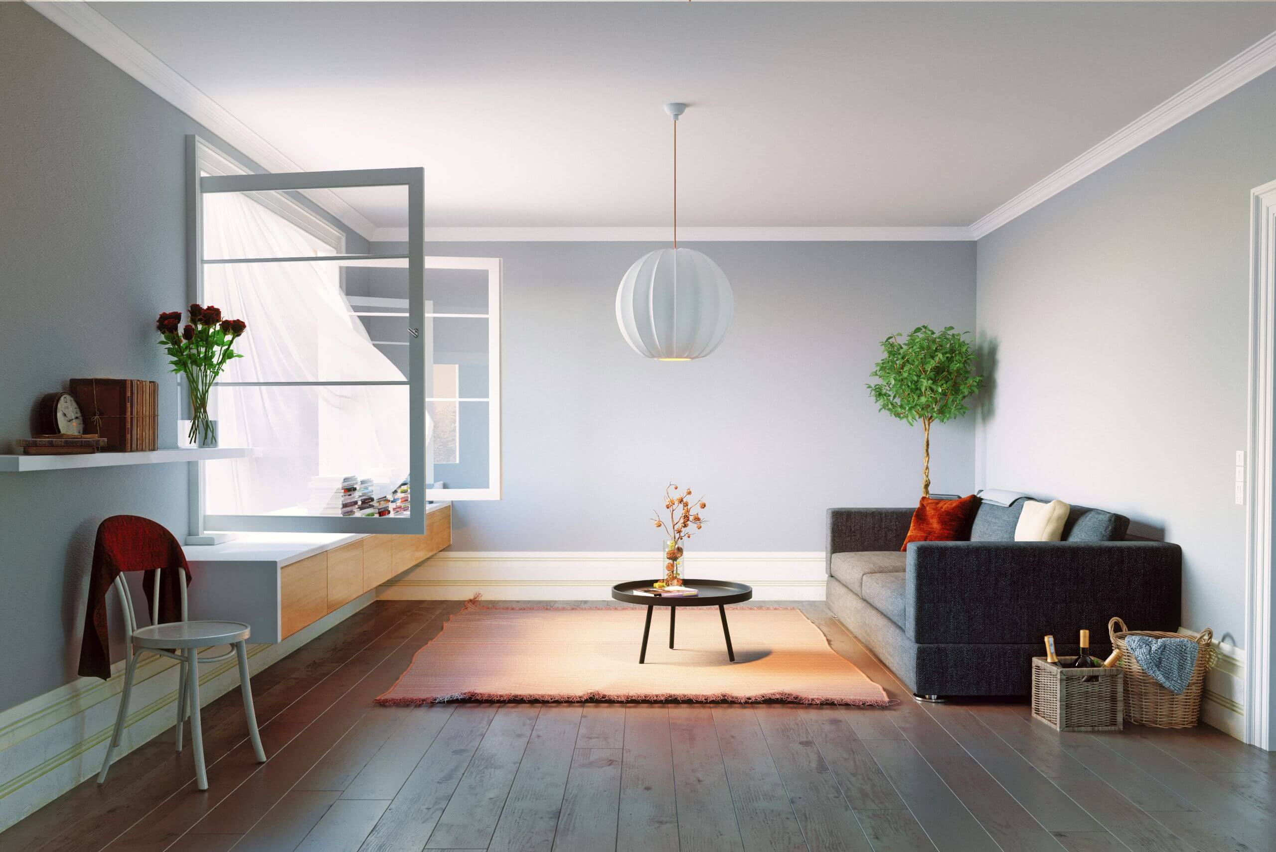 A modern living room with a gray sofa, colorful pillows, a round coffee table, and a potted plant. Sunlight streams through an open window with sheer curtains. The wooden floors highlight quality flooring in Arkansas and the minimalist decor.